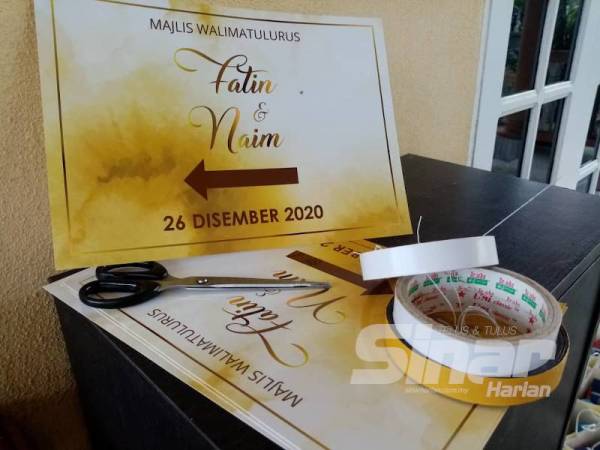 kad jemputan pasangan itu diletakkan di atas meja di hadapan pintu utama rumah pengantin