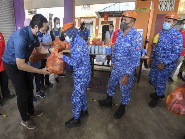 Timbalan Menteri Belia dan Sukan Wan Ahmad Fayhsal Wan Ahmad Kamal (kiri) menyampaikan sumbangan kepada sebahagian petugas barisan hadapan anggota Angkatan Pertahanan Awam Malaysia (APM) yang bertugas semasa banjir pada program Jelajah Misi Banjir Pantai Timur di Sekolah Kebangsaan Kedai Tanjong hari ini. - Foto Bernama
