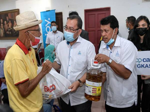Presiden Angkasa, Datuk Abdul Fattah Abdullah (dua, kiri) menyampaikan sumbangan barangan keperluan harian melalui projek Projek Barang Asas 100 (BA100) kepada salah seorang penerima yang terkesan dengan pandemik Covid-19 pada Program Tanggungjawab Sosial Koperasi (CSR) Coopcare Angkasa di Dewan Persatuan Penduduk Seksyen 1, Wangsa Maju hari ini. - Foto Bernama