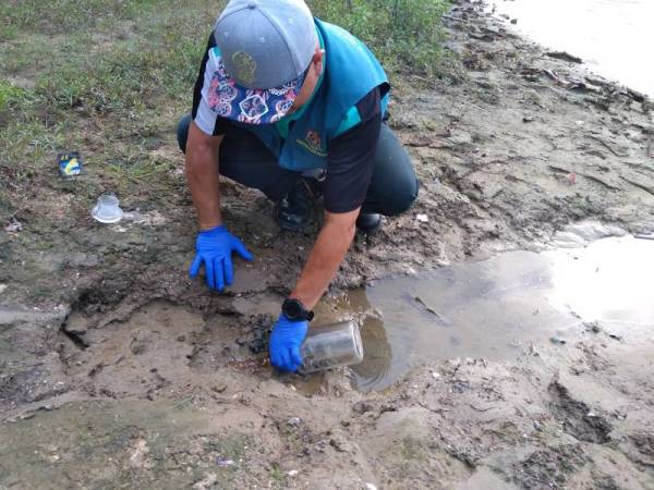 Pegawai JAS mengambil sampel air dan tanah untuk dianalisis susulan insiden ikan mati di Sungai Tumboh. - Foto ihsan JAS