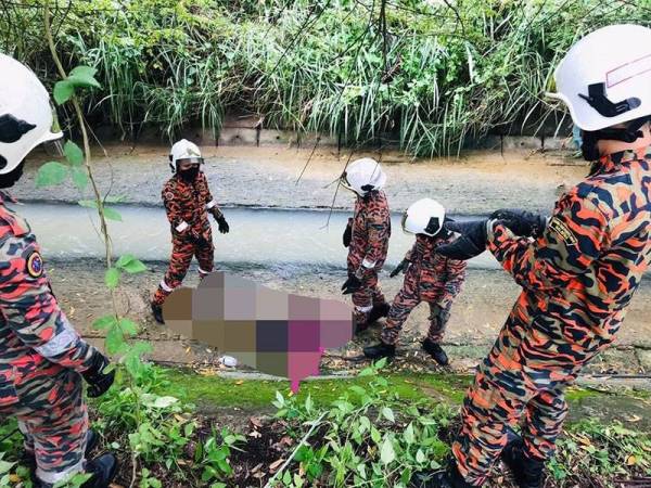 Pihak bomba menyelamatkan lelaki yang masuk dalam parit selepas tubuhnya terbakar berhampiran sebuah kuil di Jalan Ngee Heng, Johor Bahru pada Selasa.