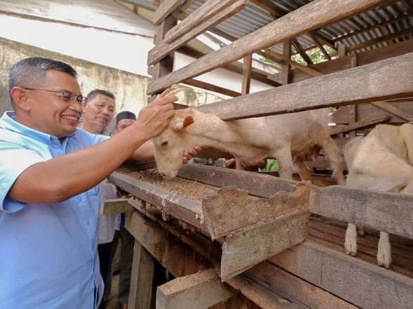 Azman (kiri) ketika meninjau lokasi ternakan kambing di Terengganu. - Foto Facebook Dr Azman Ibrahim