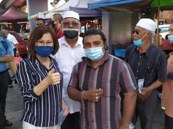 Yee Kew (kiri) bersama pemandu teksi yang ditemui semasa menyampaikan sumbangan keperluan makanan di hentian teksi hadapan pasar raya Ong Tai Kim (OTK) Batu 5, Jalan Gombak pada Selasa.