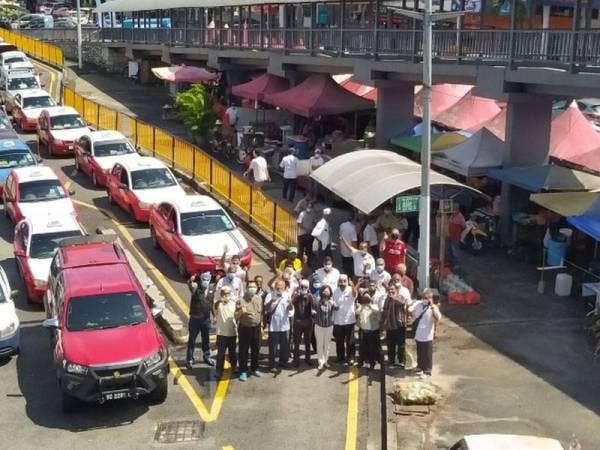 Yee Kew bergambar bersama sebahagian pemandu teksi yang menunggu pelanggan di hentian teksi hadapan pasar raya Ong Tai Kim (OTK) Batu 5, Jalan Gombak pada Selasa.