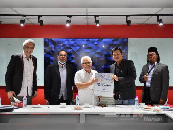 Hussamuddin (tengah) menyampaikan cenderahati kepada Helmi (dua dari kanan) sempena lawatan delegasi Majlis Ekonomi Halal dan Keusahawanan Ummah Malaysia di Kumpulan Karangkraf, Shah Alam pada Rabu. - FOTO ASRIL ASWANDI SHUKOR