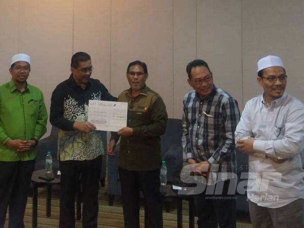 Takiyuddin (dua dari kiri) menyerahkan cek kepada penerima pada Majlis Penyerahan Cek Sumbangan daripada Kerajaan Persekutuan dan Kerajaan Negeri kepada badan bukan kerajaan (NGO) di Raia Hotel & Convention Centre pada Khamis.