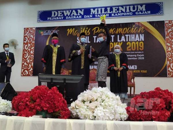 Khairul Shahril (tengah) menyampaikan Anugerah Pengerusi Eksekutif 2020 kepada Mohamad Syahrul Anuar Mohd Rasip sambil diperhatikan Nordin (dua dari kiri) pada majlis berkenaan.