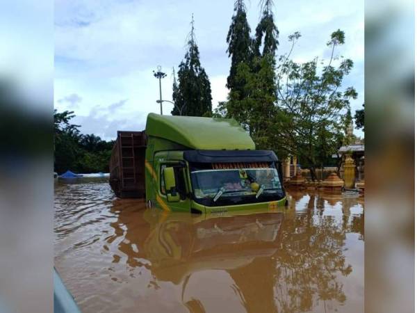 Sebuah treler terperangkap dalam kejadian banjir di kawasan Kampung Jara, Kuala Sentul, Maran pada Jumaat. - Foto JBPM Pahang