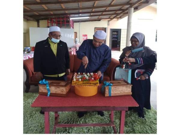  Pengarah Pusat Islam Universiti Malaysia Kelantan (UMK) selaku Penasihat PRNNK, Profesor Madya Dr Azhar Muhammad (tengah) memotong pulut kuning sebagai simbolik perasmian Pejabat PRNNK di Kubang Golok, Bachok pada Sabtu. 