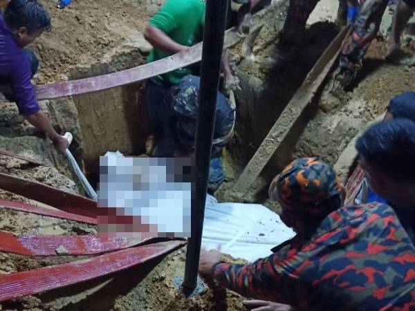 Pasukan bomba membantu menurunkan jenazah seberat 200kg ke liang lahad di Tanah Perkuburan Kampung Simpang Bejoh Jasin, pada Sabtu. - Foto ihsan bomba