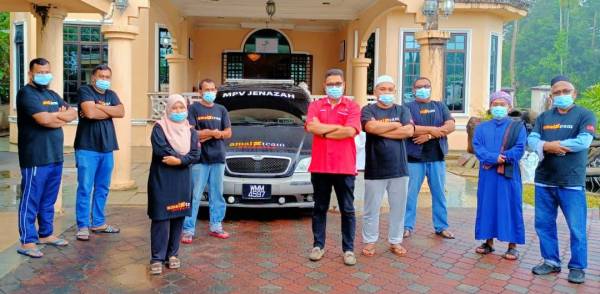 Tengku Mohd Harith (lima,kanan) bersama pasukannya bergambar di hadapan van-van jenazah yang bersedia untuk berkhidmat secara percuma kepada golongan asnaf.