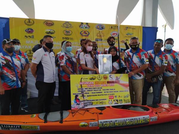 Nur Adilla (empat dari kiri) menerima sijil MBOR daripada Nurul Fatihah sambil diperhatikan Shahrul Zaman (tiga dari kanan) selepas Majlis Penutup Dayungan Ekspresi Negaraku Kayak Solo Wanita 2020 di Dataran Bagan Datuk pada Ahad.