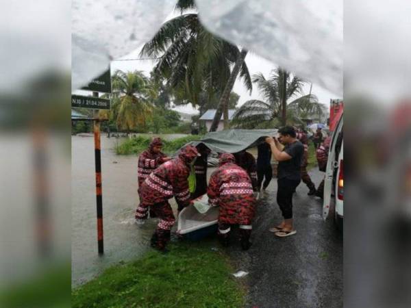 Anggota dari Balai Bomba dan Penyelamat Gebeng membantu membawa keluar pasangan warga emas yang terlibat banjir di Taman PSJ, Sungai Karang di sini pada Ahad. - Foto JBPM Pahang