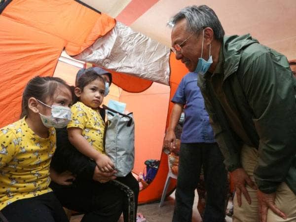 Hasni beramah mesra dengan keluarga mangsa banjir semasa mengadakan tinjauan di pusat pemindahan sementara (PPS) di Sekolah Menengah Kebangsaan (SMK) Taman Kota Jaya, Kota Tinggi pada Isnin.