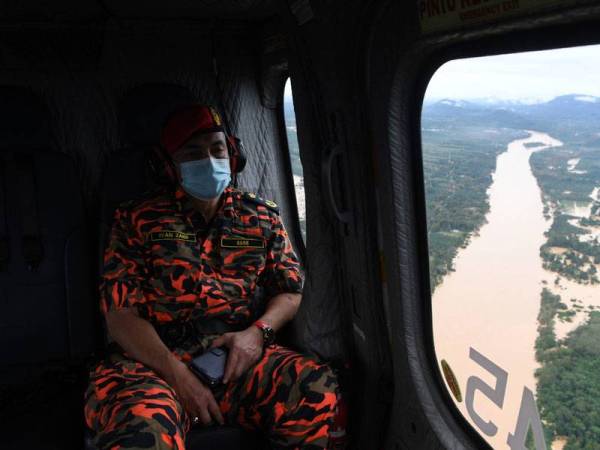 Pengarah Jabatan Bomba dan Penyelamat Malaysia (JBPM) Pahang, Ir Wan Mohammad Zaidi Wan Mohammad melihat kawasan ditenggelami banjir selepas hujan lebat turun lebih tiga hari ketika tinjauan udara bersama Bomba dan Penyelamat Malaysia (JBPM) di daerah Lipis hari ini. - Foto Bernama