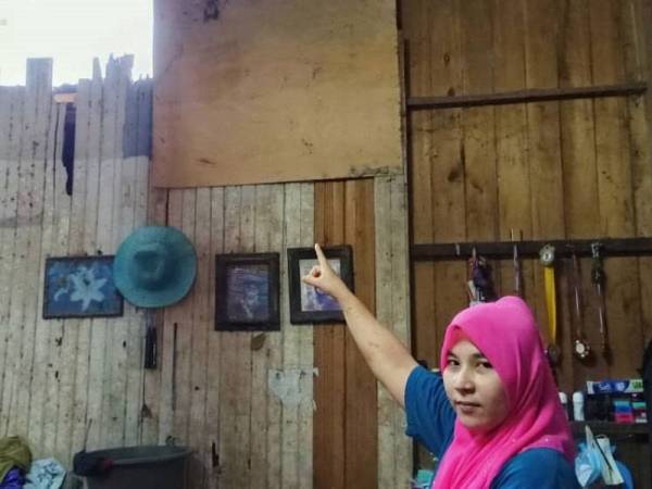 Maleha menunjukkan keadaan dinding yang usang dan berlubang.