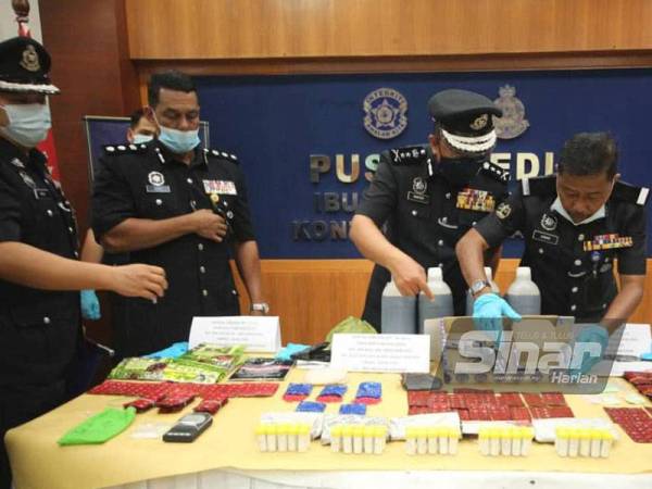 Shafien (dua dari kanan) melihat dadah jenis syabu, erimin 5, heroin, pil kuda dan kodien keseluruhannya bernilai RM135,410 serta sepucuk pistol jenis Revolver bersama tiga butir peluru hidup yang dirampas dalam serbuan membabitkan lima suspek di Rantau Panjang.