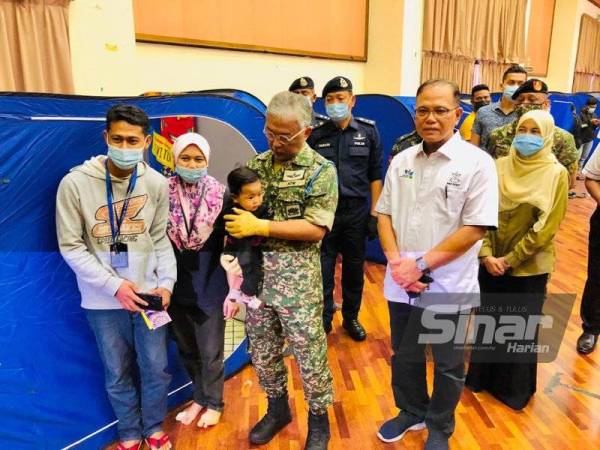 Al-Sultan Abdullah menyantuni seorang kanak-kanak di PPS Wisma Belia, Indera Mahkota, Kuantan pada Rabu.