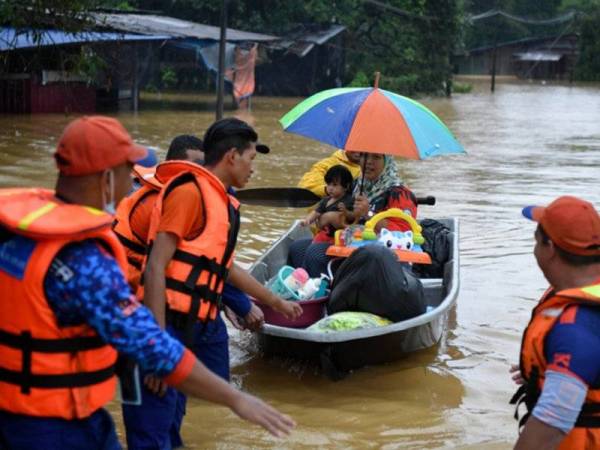 Anggota Angkatan Pertahanan Awam Malaysia (APM) menggunakan bot bagi menyelamatkan penduduk yang terjejas banjir berikutan hujan lebat ketika tinjauan di Kampung Belimbing, Jongok Batu, Dungun hari ini. - Foto Bernama