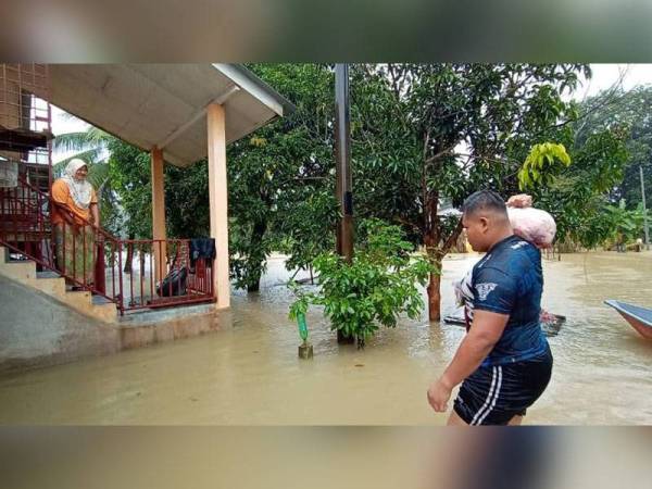 Mohd Afiq Aiman meredah banjir untuk menyerahkan ayam dipesan penduduk kampung yang terperangkap.