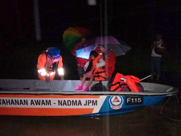 Cuaca gelap tidak menghalang anggota APM untuk melakukan tugas menyelamat mangsa banjir di Kelantan.