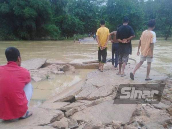 Penduduk Kampung Temalir, Kuala Krai melihat laluan utama mereka untuk keluar dari kampung dihanyutkan arus deras.