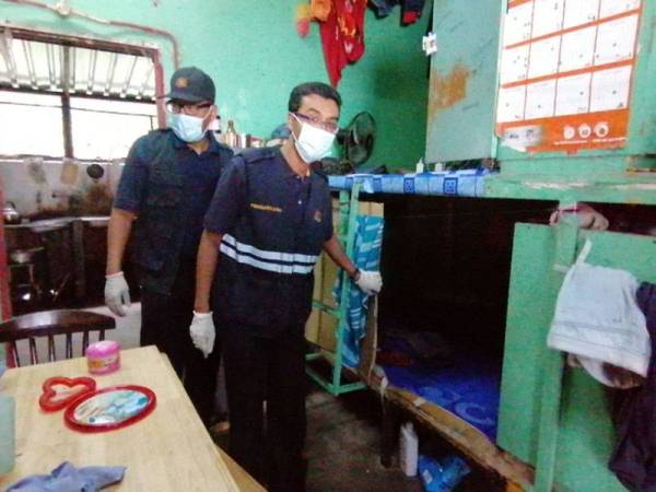 Rosli (depan) dan Zaidi melihat keadaan tempat penginapan pekerja asing.