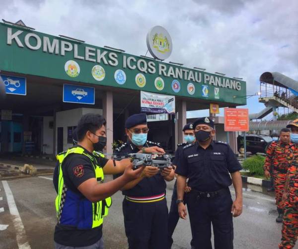 Shafien (dua dari kiri) bersama Mohamad Roy Suhaimi (kanan) ketika meninjau banjir di Rantau Panjang menggunakan dron pada Khamis.
