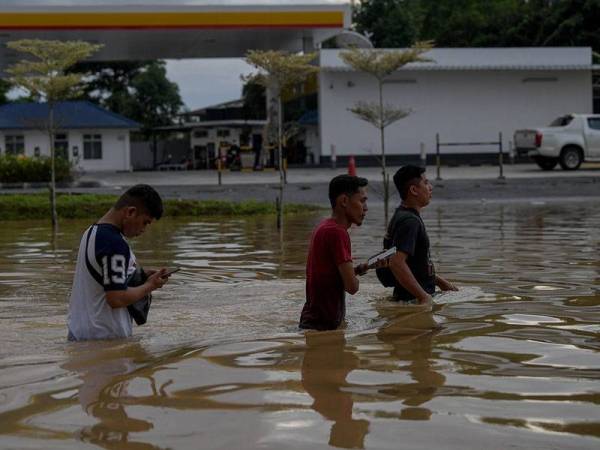 Beberapa penduduk tempatan dilihat mengharungi air dengan kedalaman hingga ke paras pinggang di bandar Mentakab ketika tinjauan banjir di sekitar negeri Pahang hari ini.