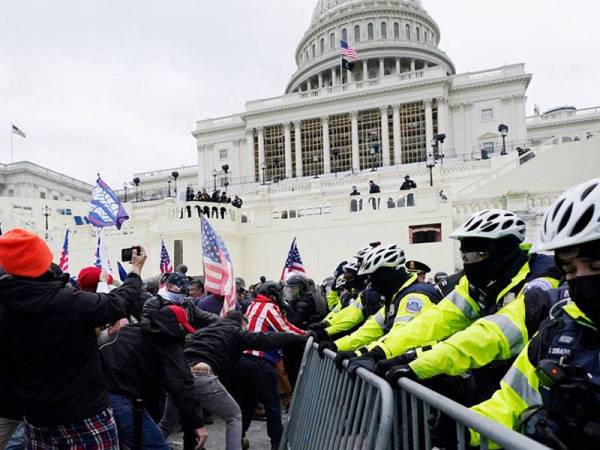 Kumpulan perusuh bertindak merobohkan sekatan yang dipasang pihak berkuasa di sekitar bangunan Capitol.