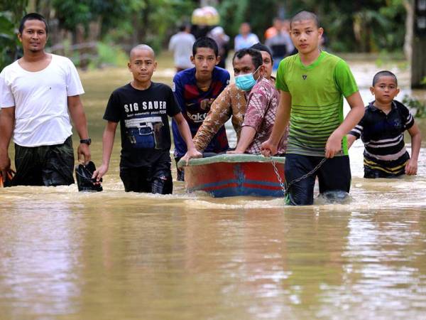 Golongan pelajar kelihatan menggunakan bot untuk membawa bekalan makanan ke sebuah sekolah pondok di Sai Buri, Pattani.
