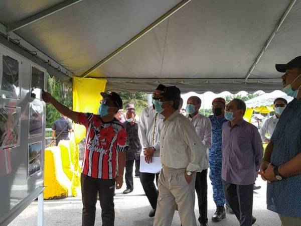 Zainol Fadzi (kiri) memberikan taklimat kepada Raja Jaafar mengenai situasi banjir yang berlaku di sekitar kawasan Dewan Undangan Negeri (DUN) Sungai Manik.