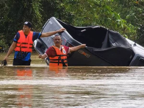 Pihak berkuasa membantu mengeluarkan pacuan empat roda yang terperangkap di bawah jambatan Lebuhraya Pantai Timur 2 (LPT2) di Chukai pagi Sabtu. - Foto ihsan polis