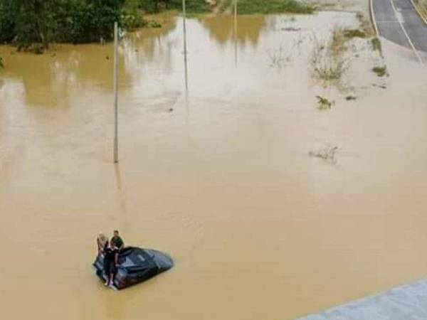Sebuah pacuan empat roda yang terperangkap dalam banjir di bawah jambatan Lebuhraya Pantai Timur 2 (LPT2) di Chukai pagi Sabtu. - Foto ihsan polis