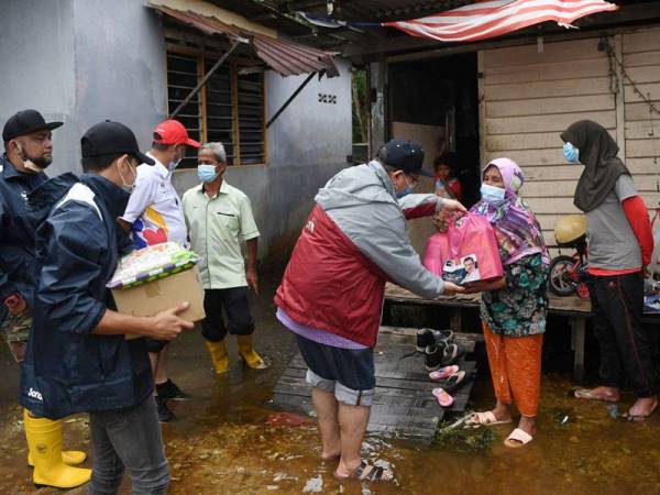 Saifuddin menyampaikan bantuan kepada mangsa banjir di Kampung Chendering, Kuantan pada Sabtu. - Foto Bernama