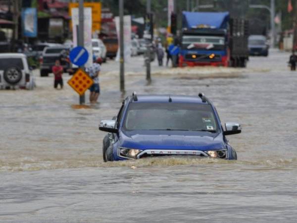 Sebuah kenderaan pacuan empat roda kelihatan meredah air banjir untuk ke pekan berikutan sebahagian jalan untuk ke Rantau Panjang telah ditenggelami air pada Khamis. - Foto Bernama