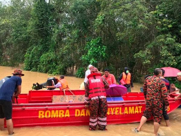 Bomba dan Penyelamat Temerloh dibantu penduduk kampung mengangkat jenazah ke dalam bot untuk dibawa ke di Tanah Perkuburan Kampung Desa Baru Purun hari ini. - Foto Bernama