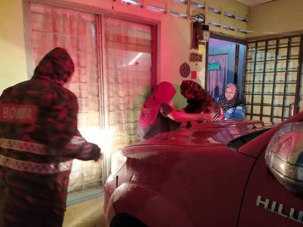 Anggota bomba memindahkan seorang wanita warga emas yang terperangkap di dalam rumahnya akibat banjir di Teluk Ramunia, Kota Tinggi pada Ahad.