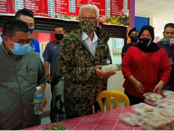 Ismail Sabri (dua dari kiri) turut sama menikmati makanan yang siap dibungkus di PPS SK Rantau Panjang 2.