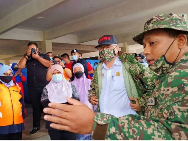 Ismail Sabri (dua dari kanan) mendengar taklimat daripada pegawai ATM yang bertugas di PPS SK Rantau Panjang 2.