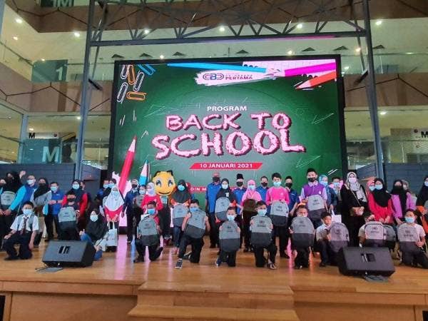 Kamari Zaman (tengah) bergambar bersama penerima bantuan bagi program 'back to school' yang diadakan pada Ahad.