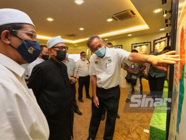 Abdul Hadi (tengah) melawat galeri MADA sebelum program libat urus bersama peladang di Ibu Pejabat MADA, Ampang Jajar, Alor Setar pada Khamis.