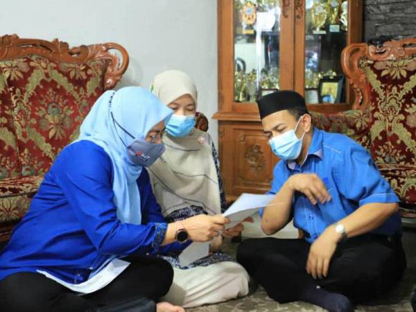 Noraini berbincang dengan Mahasan semasa melawat dan menyampaikan sumbangan serta pampasan Takaful RM25,137 kepada keluarga arwah Ikmal Hakimi di Taman Suria, Kluang, pada Ahad.