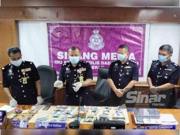 Mazuki (dua dari kiri) menunjukkan rampasan dalam serbuan aktiviti perjudian sabung ayam di sebuah ladang kelapa sawit di Changkat Lobak, Alor Pongsu pada Ahad.