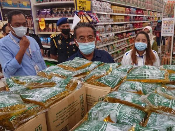 Ismail (dua dari kiri) dan Norena (dua dari kanan) melihat bekalan minyak masak paket ketika mengadakan tinjauan di Pasaraya Mydin, Pusat Dagangan Antarabangsa Melaka (MITC) Ayer Keroh, Melaka pada Selasa.