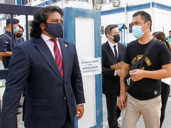 Dev Kumaraendran (kiri) mengiringi anak guamnya di IPDTL pada tengahari Rabu.