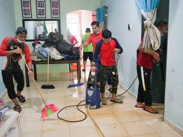 Sukarelawan membersihkan kediaman mangsa banjir di Kemaman yang dipenuhi lumpur.