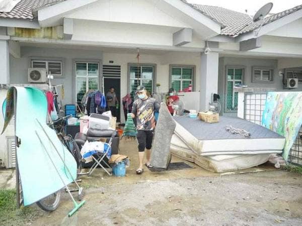 Sukarelawan membersihkan kediaman mangsa banjir di sekitar Kemaman.