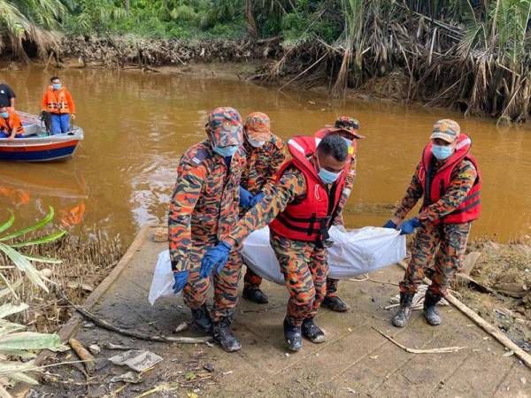 Anggota bomba mengangkat mayat mangsa yang ditemui terapung di Sungai Sabak. - Foto: Ihsan bomba
