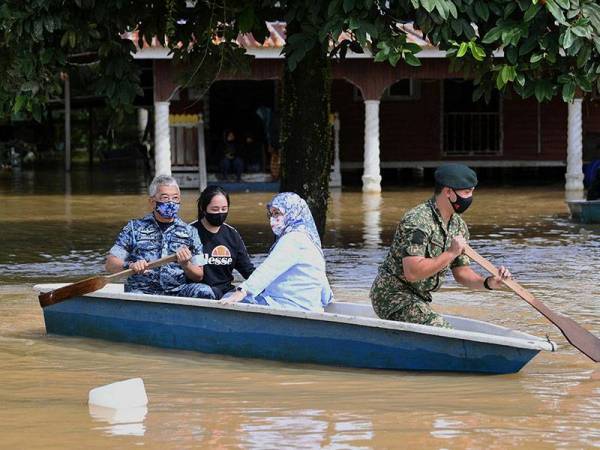 Al-Sultan Abdullah bersama anakanda Tengku Muhammad Iskandar Ri'ayatuddin Shah mendayung sendiri sampan ketika berkenan mencemar duli meninjau situasi banjir di Daerah Pekan, pada Khamis. - Foto Bernama
